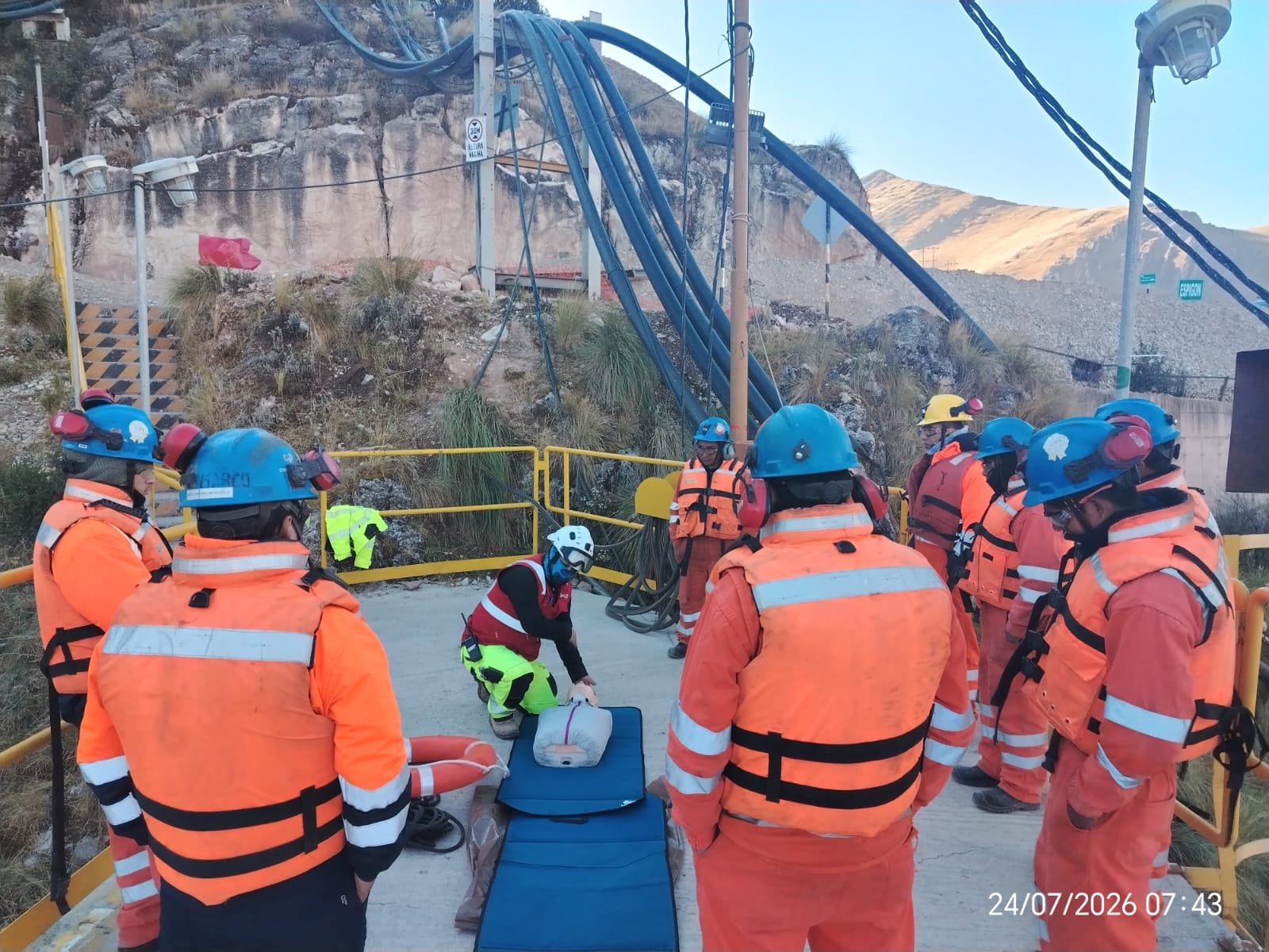 Servicios Simulacro de primeros auxilios con maniquí de reanimación frente a trabajadores con chalecos salvavidas